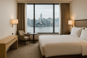 Hotel room overlooking a city skyline at sunset.